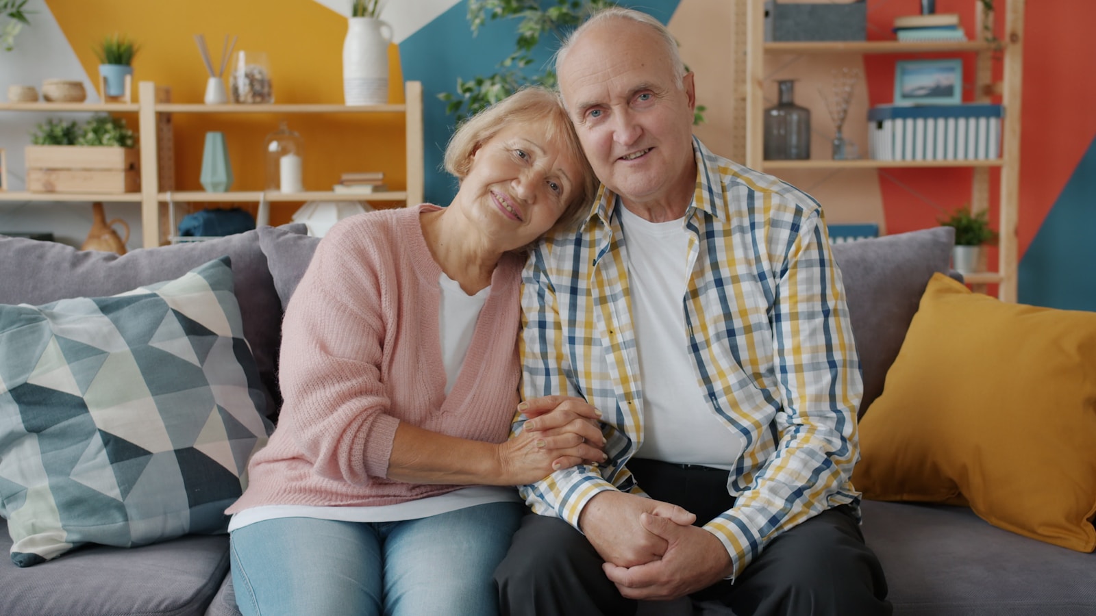 Ældre par sidder tæt sammen i sofaen